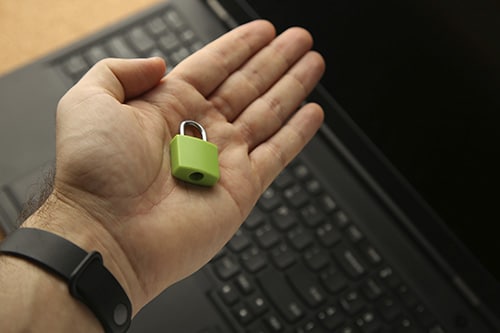 hand holding green pad lock